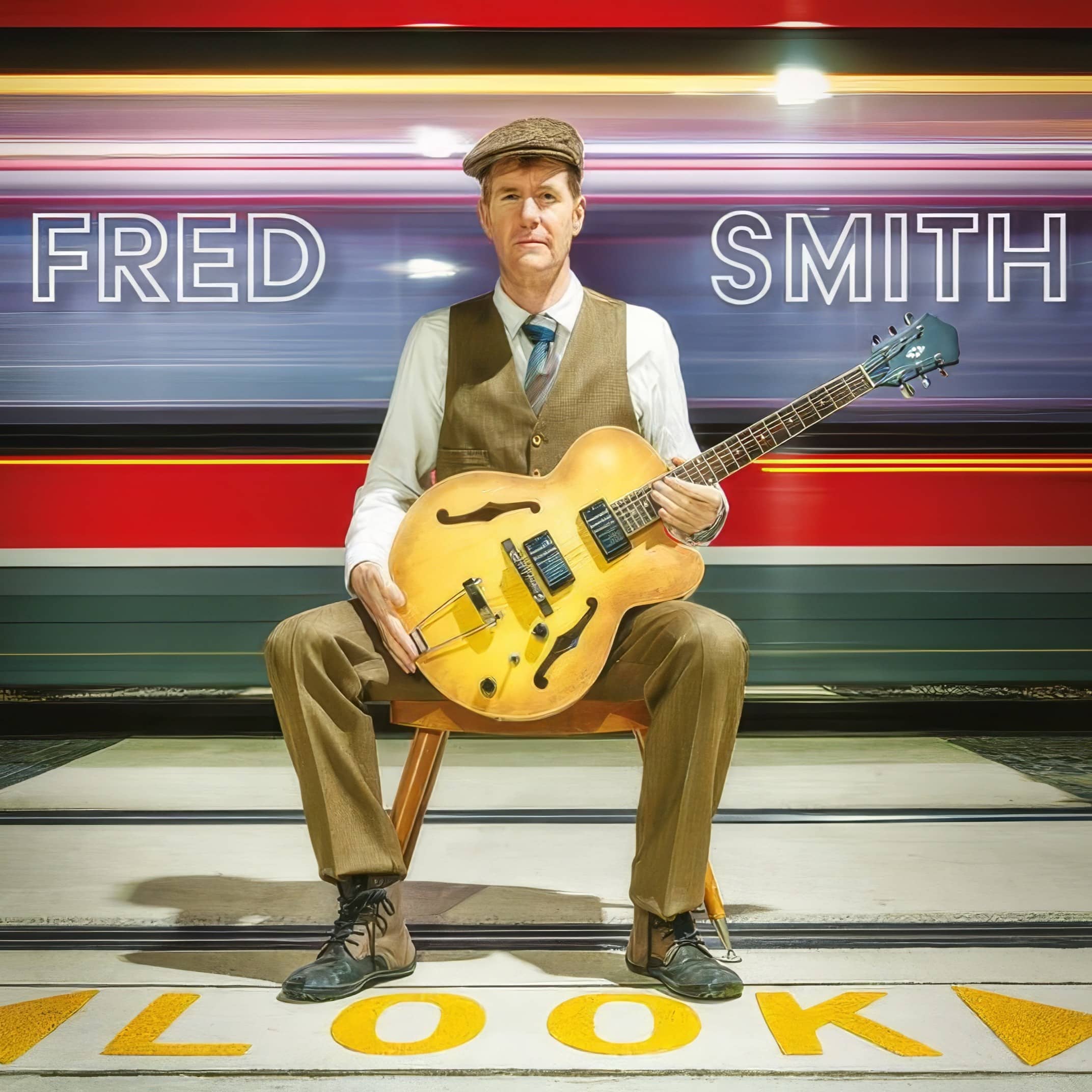 Fred Smith's album cover Look: Fred with a hollow-body guitar on a station platform as a train streaks past, his name in neon-style type.